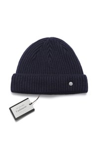 Bonnet en tricot côtelé marine en mélange de cachemire, avec un revers et un petit logo métallique en accent. Étiquette attachée visible.