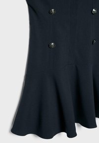 Tmavomodré šaty s rozšíreným lemom a dvojitým radom ozdobných strieborných gombíkov na prednej strane.