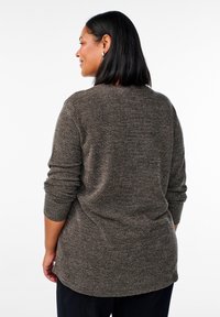 Brązowy sweter o fakturze z rękawami 3/4, z dekoltem wyciętym w serek i subtelnym wzorem w jodełkę, widoczny z tyłu.