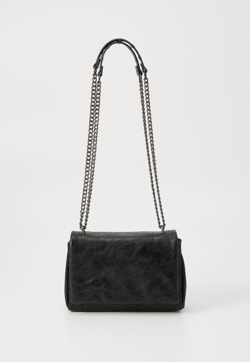 Borsa a spalla in pelle nera con chiusura a pattina e lunghe catene metalliche doppie, poggiata su uno sfondo bianco semplice.