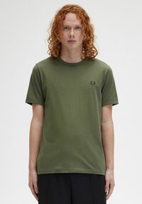 T-shirt in cotone verde oliva con scollo rotondo, maniche corte e un piccolo logo ricamato sul lato sinistro del petto. Texture liscia.