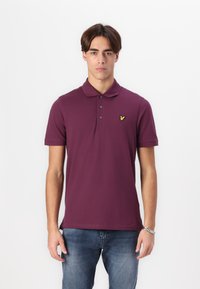 Bordový polo tričko vyrobené z hladkej látky, s klasickým golierom, tromi gombíkmi a malým žltým logom na ľavej hrudi.