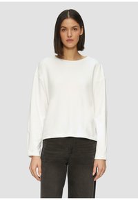 Witte, lange mouwen sweatshirt met een wijde halslijn en een ontspannen fit, gemaakt van zachte stof. Draagt met donkergrijze, slim-fit jeans.