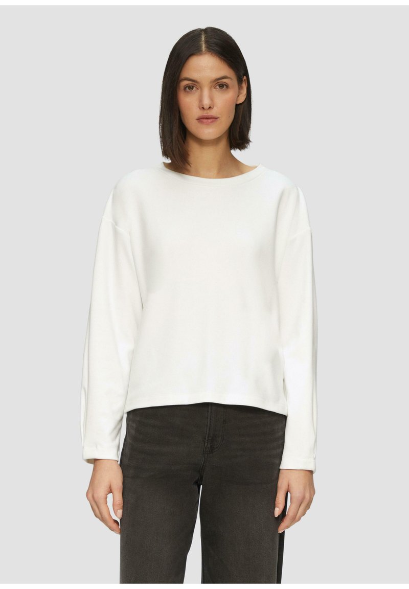Witte, lange mouwen sweatshirt met een wijde halslijn en een ontspannen fit, gemaakt van zachte stof. Draagt met donkergrijze, slim-fit jeans.