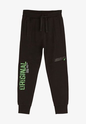 Svarte joggingbukser med snøre i taljen, sidelommer, grøn lynlåslomme på låret og grøn "ORIGINAL" tekst med mindre hvid tekst på venstre ben.