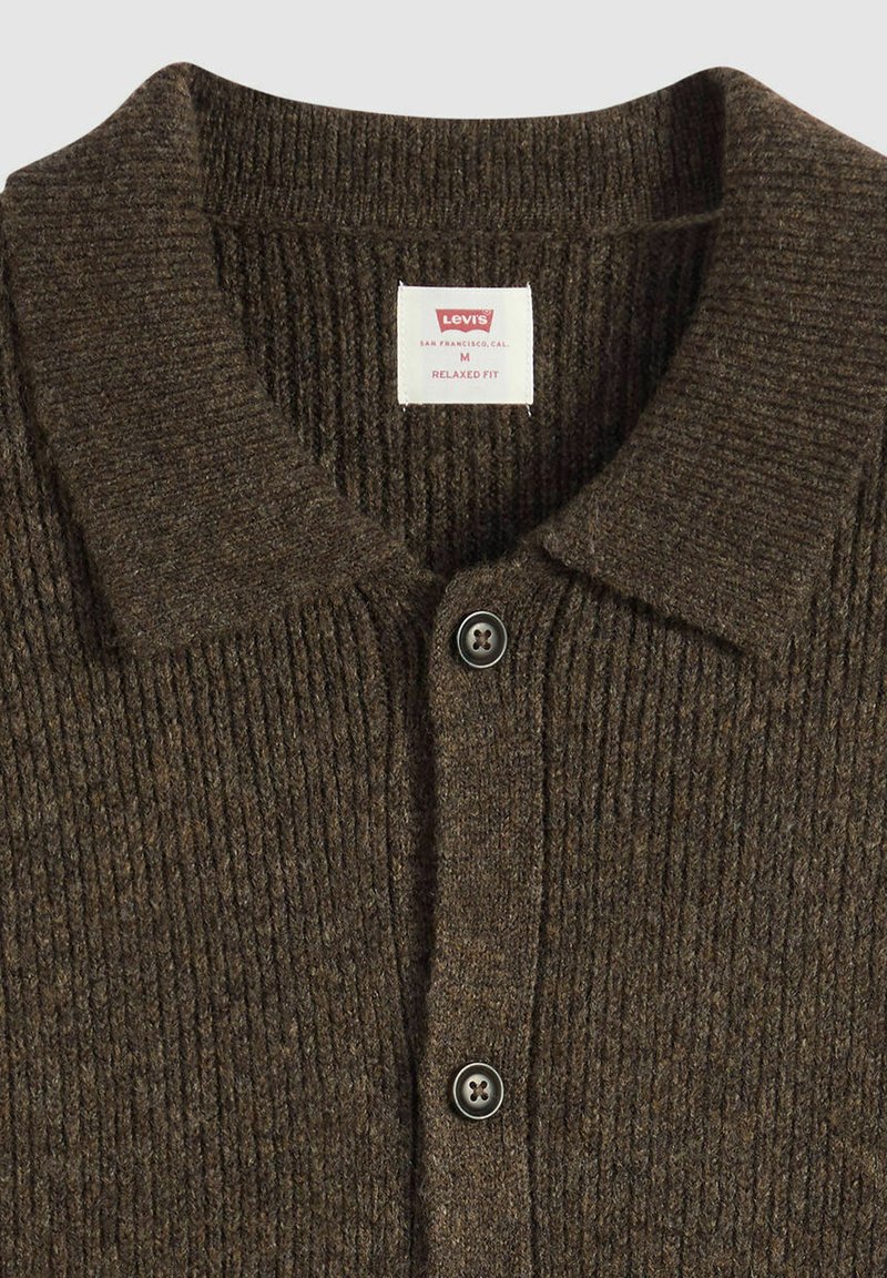 Cardigan marron en maille côtelée avec un col à revers, portant une étiquette indiquant "Levi's" et deux boutons foncés sur la patte de boutonnage avant.