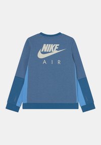 Nike sweatshirt i blå nyanser, med en stor vit logotyp och "AIR"-text på baksidan. Slät textur med kontrasterande ärmdetaljer.