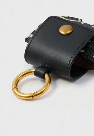 Suport de chei din piele neagră cu buton auriu și inel de cheie circular auriu atașat, pe un fundal alb.
