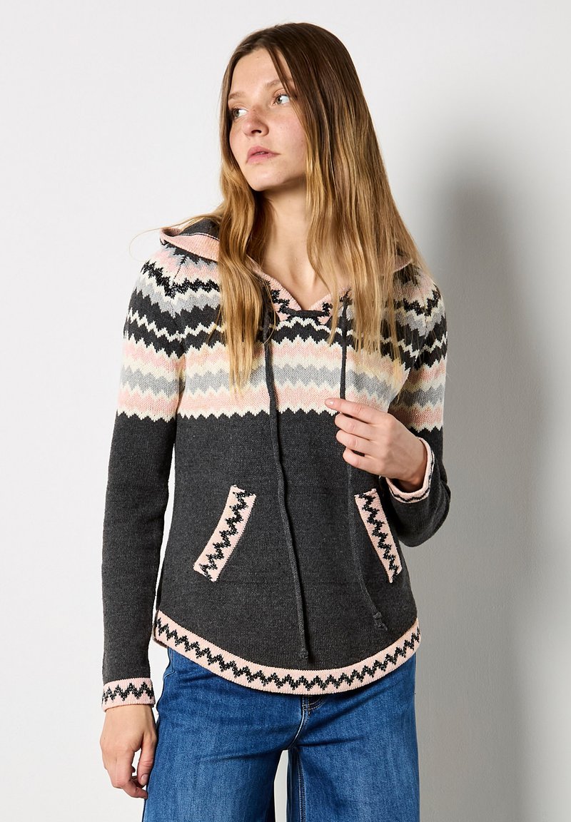 Sudadera de punto gris con un patrón de zigzag en rosa y negro, que incluye cordones, bolsillos delanteros y un dobladillo ligeramente curvado.