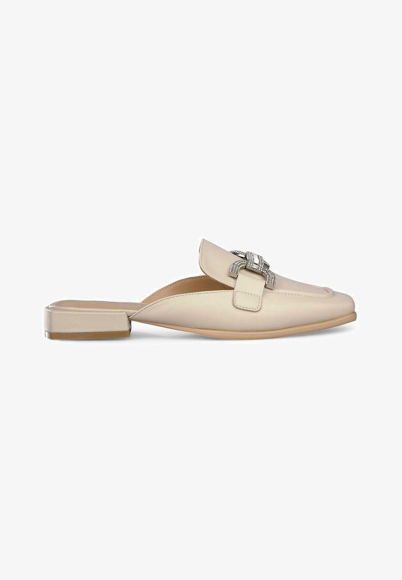 Scarpa slip-on in pelle beige con un leggero tacco, caratterizzata da una decorativa fibbia in tonalità argento sul davanti. Texture liscia, design classico.