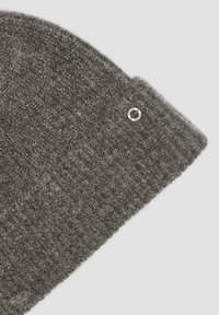 Grijze gebreide beanie met een gestructureerd patroon, met metalen draadjes. Inclusief een ronde zilveren hardwaredetail met gravure.