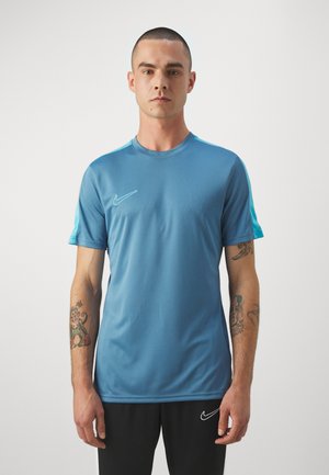 Maglietta sportiva blu realizzata in tessuto morbido, con maniche corte e scollatura rotonda. Logo Nike in bianco sul lato sinistro del petto.