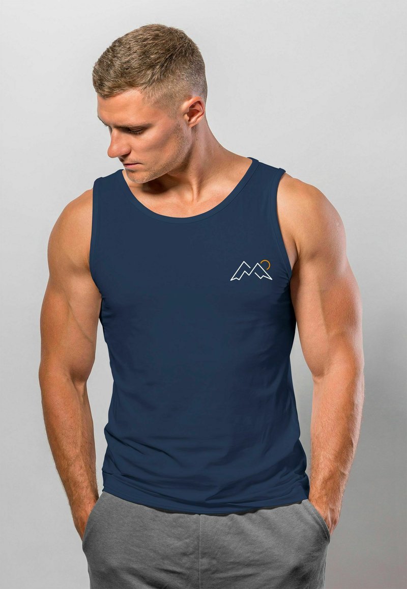 Navy blue tank top with a rounded neckline, featuring a small, white mountain graphic with an orange accent. Smooth fabric texture.