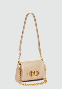 Sac à main en cuir beige avec une bandoulière en chaîne dorée et un matériel doré proéminent. Dispose d'une fermeture à crochet avec un détail de logo circulaire.