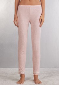 Lichtroze pyjamabroekjes van zachte stof, met een aansluitende pasvorm en kantafwerking aan de onderkant, met een gladde textuur over het geheel.