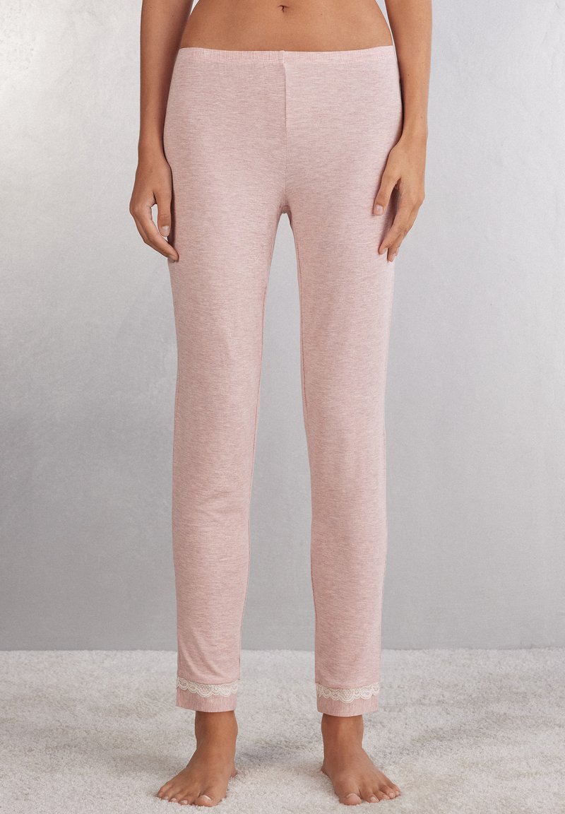 Lichtroze pyjamabroekjes van zachte stof, met een aansluitende pasvorm en kantafwerking aan de onderkant, met een gladde textuur over het geheel.