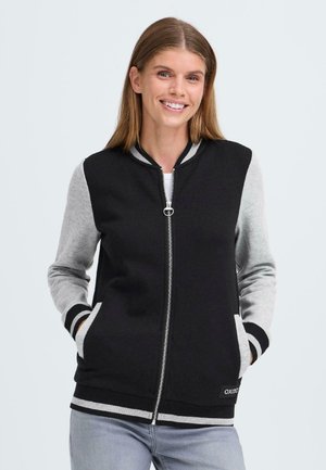 Sort og grå zip-up hættetrøje med ribbede manchetter, lommer og et logo mærke. Blødt stof kombinerer kontrasterende farver i et sporty design.