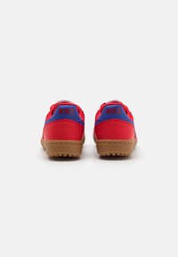 Røde og blå Nike sneakers med en tekstureret gummisål. Har en polstret krave og fremtrædende Nike-branding på hælen, rund form.