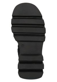 Suela de zapato de goma negra con una superficie texturizada, que presenta surcos horizontales y un acento circular con el número 31.