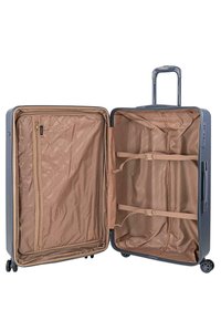 Maleta de tapa dura gris con interior marrón. Cuenta con un bolsillo con cremallera y cuatro correas elásticas para asegurar el contenido. Incluye un mango retráctil.