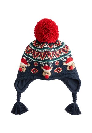 Marineblau gestrickte Mütze mit einem großen roten Pompon, dekorativen Rentiermustern und geflochtenen Fransen an den Ohrklappen. Akzente in Rot und Creme.