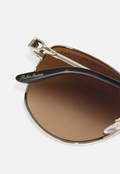 Brown gradient sunglasses with gold metal frame and detailing. The temple features a glossy black finish with embossed "Ralph Lauren" logo.