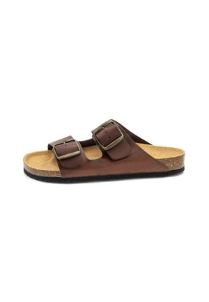 Brown leather two-strap sandal with adjustable metal buckles, cork footbed, and black rubber sole. Features a smooth texture and minimalist design.