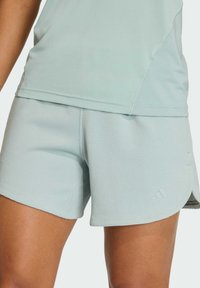 Lichtblauwe sportshorts van gestructureerde stof, met een licht gebogen zoom en een klein logodetail aan de zijkant.