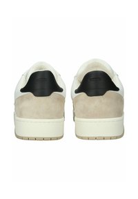 Zapatillas blancas de cuero con acentos de gamuza beige en el talón y lengüetas negras en el talón. Se aprecian tejidos texturizados y una suela de goma.