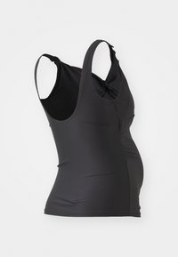 Débardeur noir avec un design ajusté, texture lisse, bretelles réglables et un détail torsadé dans le dos, adapté pour les vêtements de maternité.