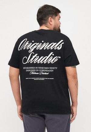 Black cotton T-shirt featuring white text on the back, with stylish script for "Originals Studio," and additional printed details below.