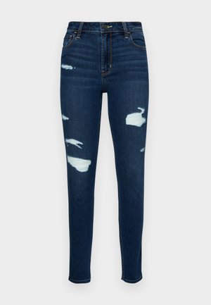 Tmavě modré skinny džíny vyrobené z denimu, s opotřebovanými záplatami a třepenými detaily. Klasický design s pěti kapsami a zipovým zapínáním.