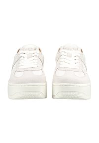 Paire de baskets blanches à plateforme avec des semelles épaisses texturées et des lacets à l'avant, vues de face sur fond blanc.