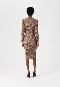 Kroppsskjørt, langermet kjole i leopardmønster. Har høy hals og knelang fasong, laget av glatt, fleksibel stoff.