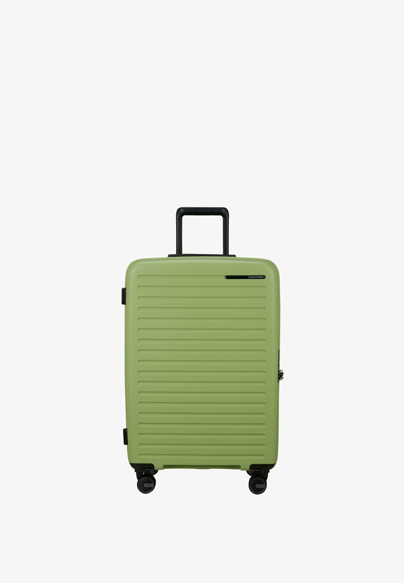 Green hard-shell suitcase with horizontal ridges, black retractable handle, and four black spinner wheels.