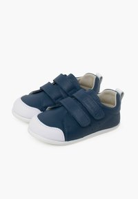 Baskets en cuir bleu avec un bout et une semelle en caoutchouc blanc. Dotées de deux bandes Velcro, d'un bout arrondi et de petites perforations pour la ventilation.