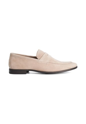 Beige suede men's loafer with a low black heel and a stitched strap detail across the upper, shown in profile on a white background.