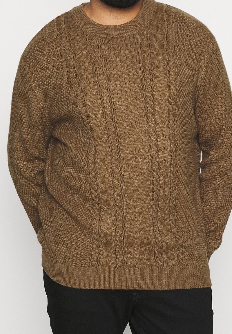 Hnědý pletený svetr s texturovanými vzory, výstřihem do oblouku a žebrovanými manžetami. Volný střih s cable-knit detaily na přední straně.