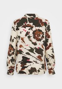 Long-sleeve shirt in cream with a floral pattern in dark green, brown, and pink. Features a collar and buttoned cuff. Fabric appears textured.