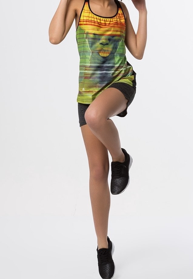 Sporttanktop met een kleurrijke grafische print en een zwart accent, gecombineerd met donkere shorts en gestructureerde zwarte sneakers.