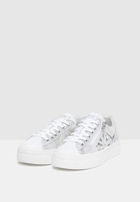Baskets blanches avec une touche métallique argentée, des superpositions en suède et cuir lisse, un bout rond et une semelle blanche épaisse avec des lacets.