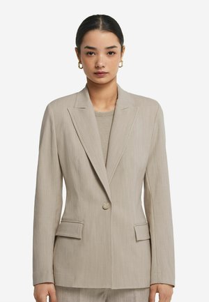 Blazer beige realizzato in tessuto texture, con revers a punta, chiusura con un solo bottone e due tasche anteriori. Design minimalista.