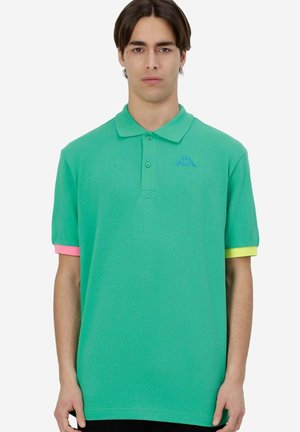 Polo verde con maniche corte; presenta rifiniture a contrasto in rosa e giallo sui polsini e un logo blu sul petto. Materiale in cotone.