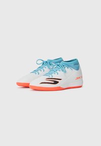 Chaussures de sport blanches avec un dessus texturé, des accents bleus et une semelle orange vif, avec un logo noir et un système de laçage.
