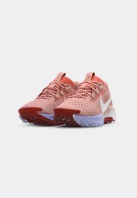 Roze i crvene atletske tenisice s mrežastim gornjim dijelom, podstavljenim jezikom i veznim dizajnom. Imaju teksturiranu gumenu potplat i bijeli Nike swoosh akcent.