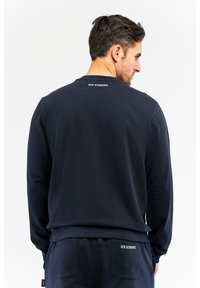 Marineblaues Sweatshirt mit langen Ärmeln, Rundhalsausschnitt und strukturiertem Stoff. Mit "ICE ICEBERG"-Logo auf der Rückseite und lockerer Passform.