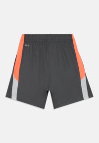 Pantaloni sportivi da uomo in grigio scuro, con pannelli laterali arancioni e grigi, vita elastica e tessuto traspirante.