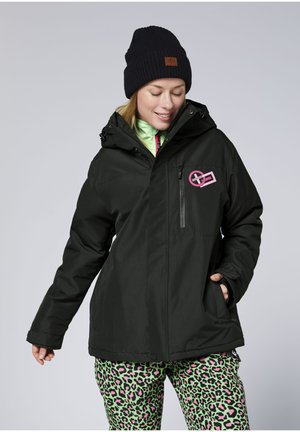 Black insulated jacket with a hood, featuring a pink logo on the chest pocket. Paired with green pants featuring a pink leopard print pattern.