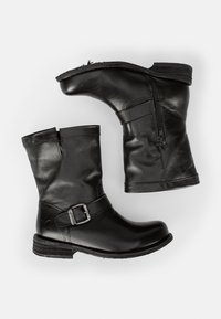 Stivaletti in pelle nera, con cerniera laterale, punta tonda, accento decorativo con fibbia e tacco basso impilato. Texture liscia e finitura lucida.