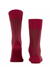 Chaussettes rouges avec une élégante bordure côtelée et des rayures verticales contrastantes marron. Fabriquées à partir d'un matériau doux avec une texture lisse.